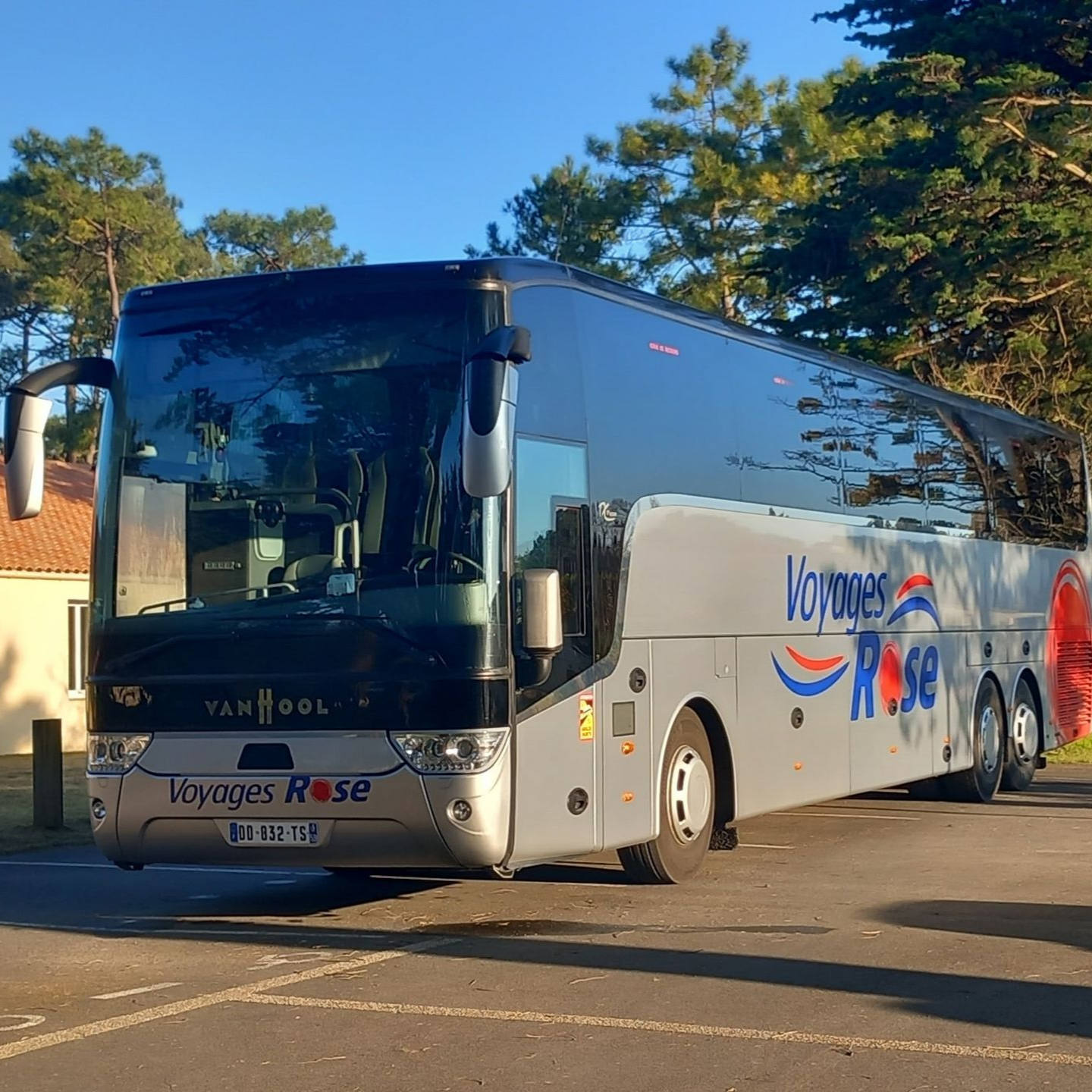 Un bus gris Voyages Rose est garé dehors.
