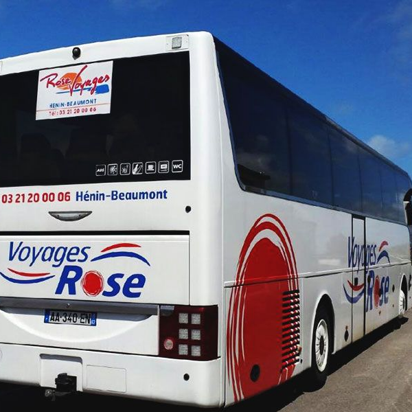 Arrière d'un autocar blanc arborant le logo rouge et bleu des Voyages Rose.