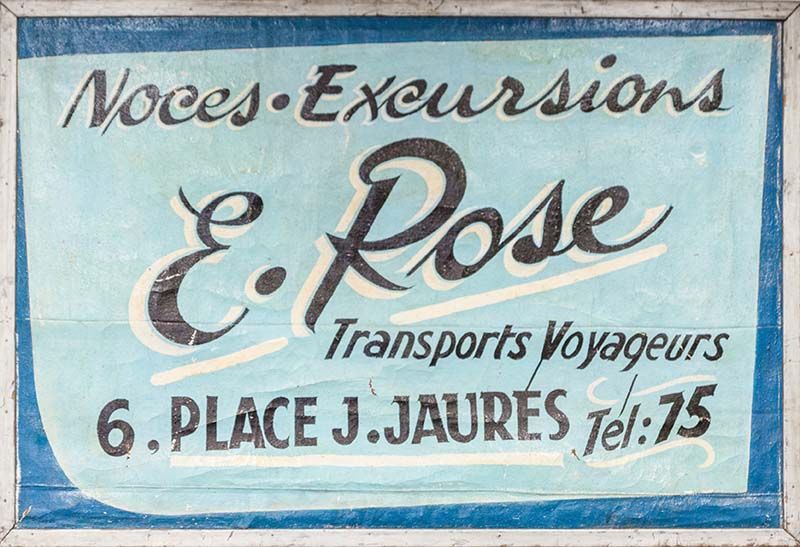 Ancienne enseigne de E. Rose, transports de voyageurs.