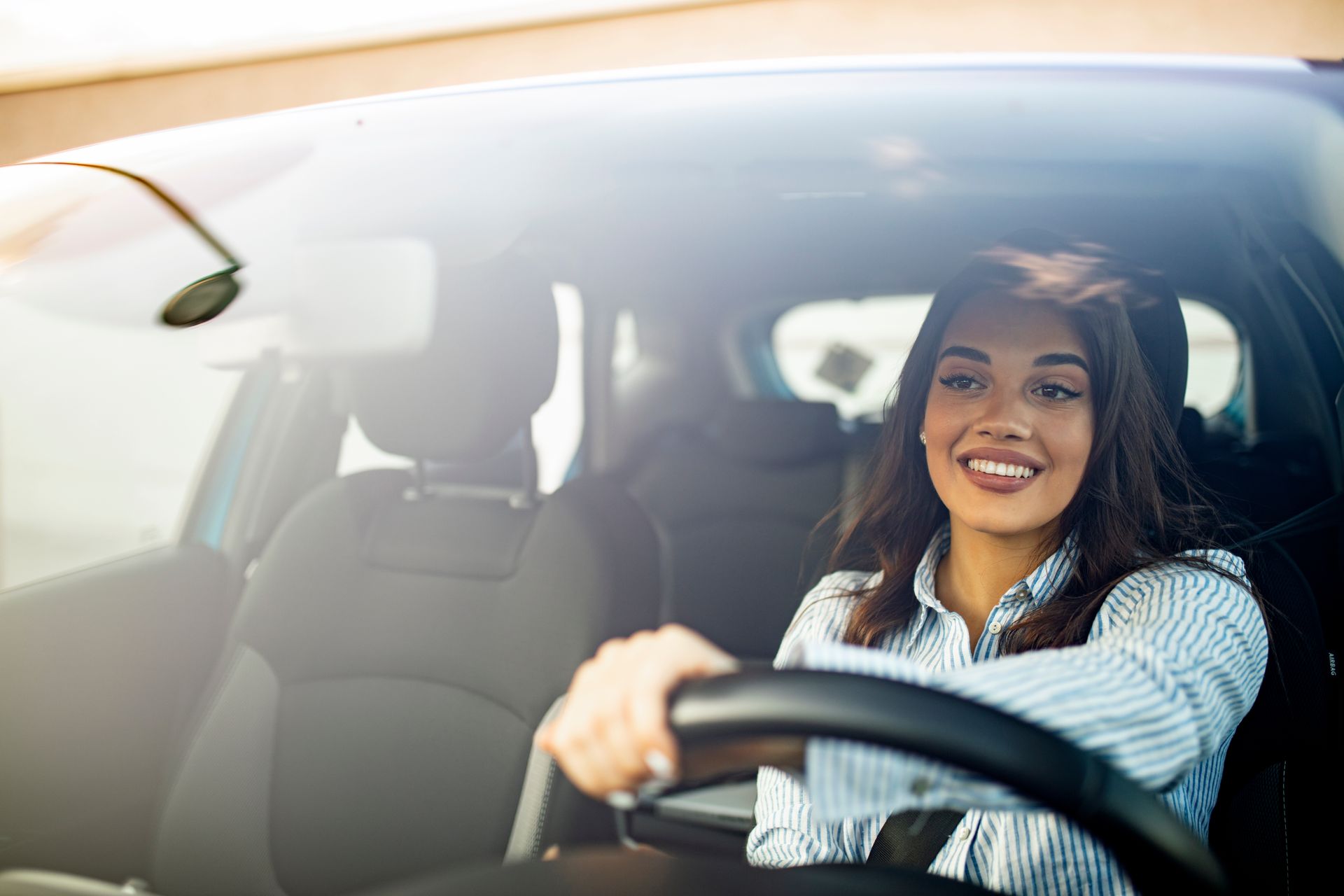 Femme avec une chemise bleue au volant d'une voiture