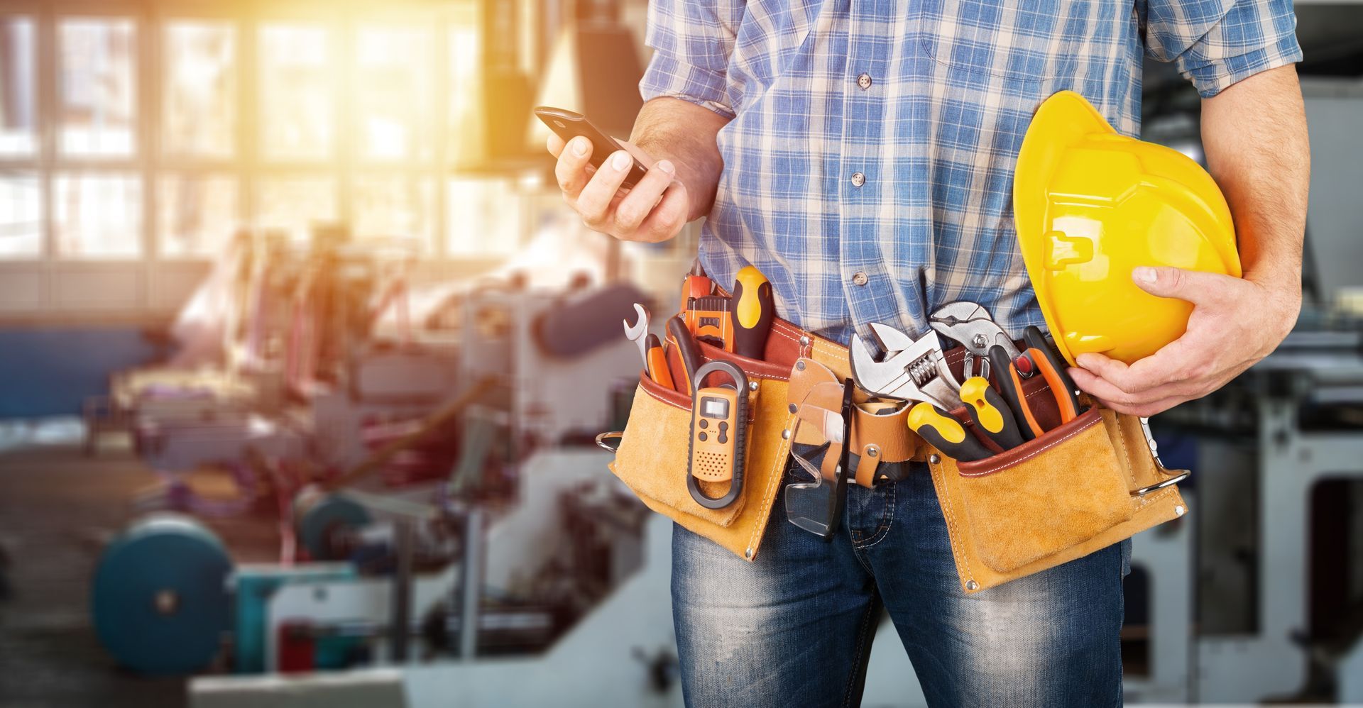 Homme avec une ceinture d'outils et un casque jaune