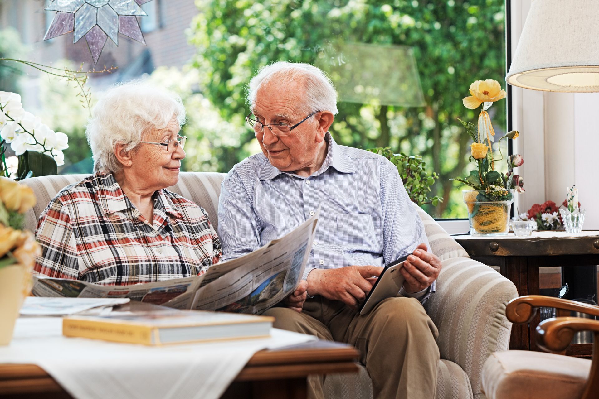 Couple qui discute en lisant le journal dans un canapé