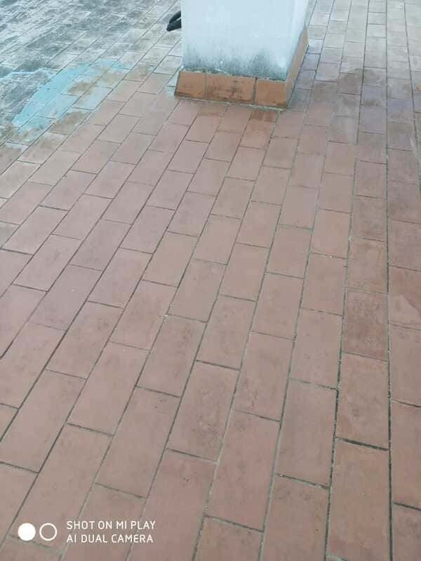 Un primer plano de un piso de ladrillo con un pilar al fondo.