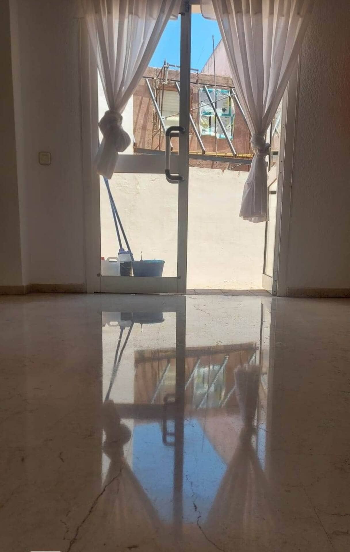 Una habitación con una puerta corrediza de vidrio que conduce a un balcón.