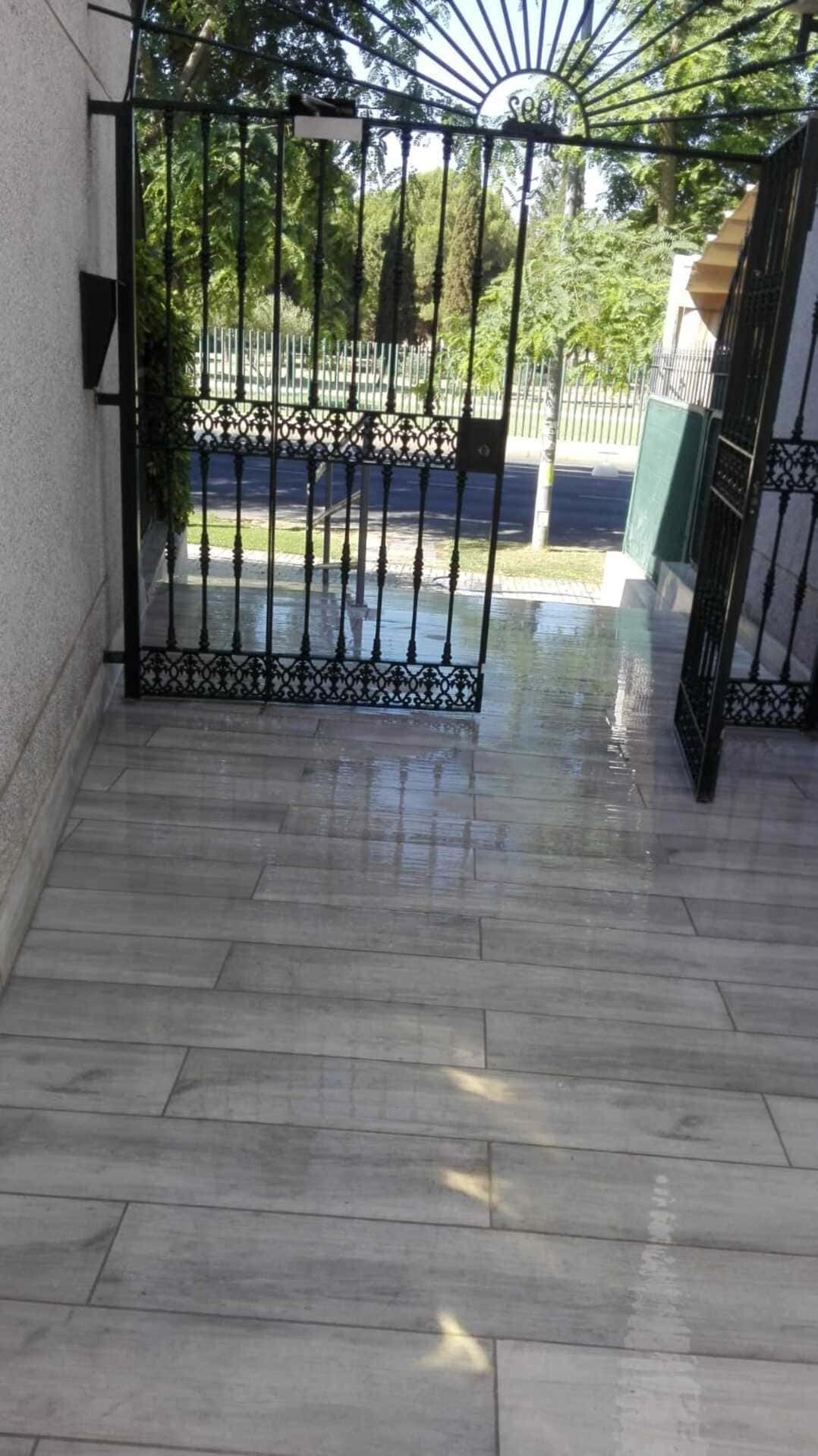 Un suelo de madera con una puerta de hierro forjado al fondo.