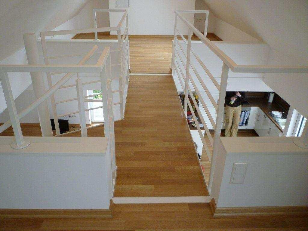 Innenansicht: Holzsteg mit weißem Geländer, Blick auf die untere Ebene mit Person.