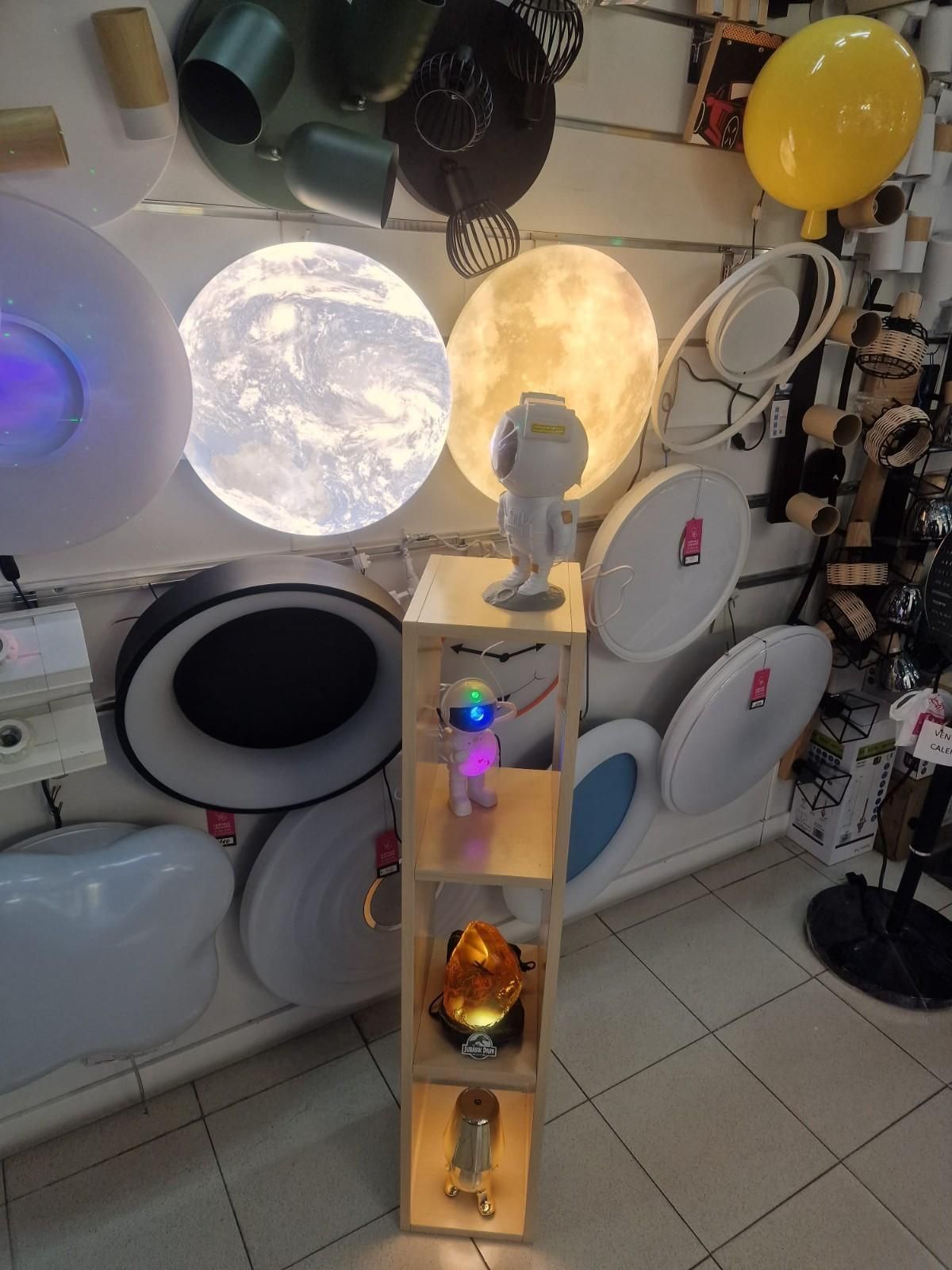 Un escaparate comercial con apliques de pared redondos e iluminados que recuerdan a lunas y planetas