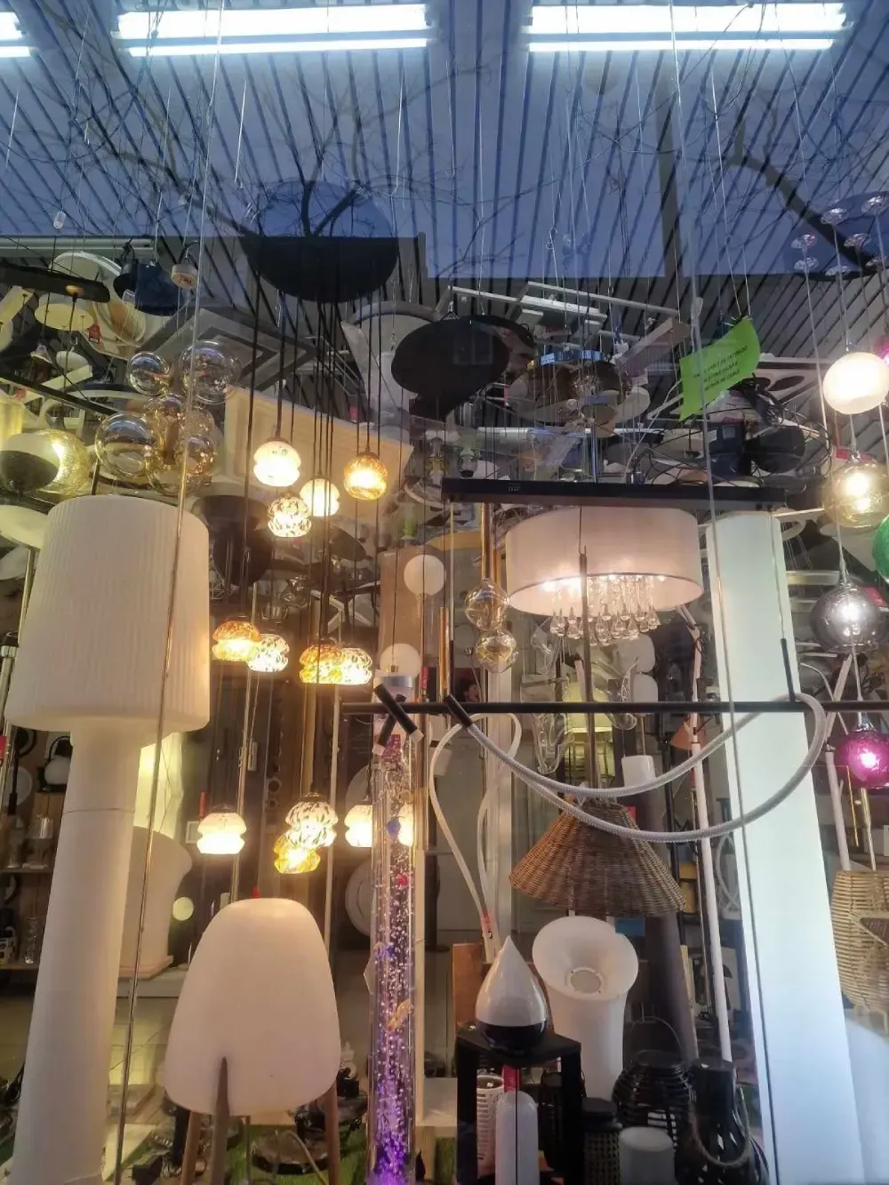 Un concurrido escaparate con diversos tipos de lámparas de interior, incluyendo candelabros colgantes