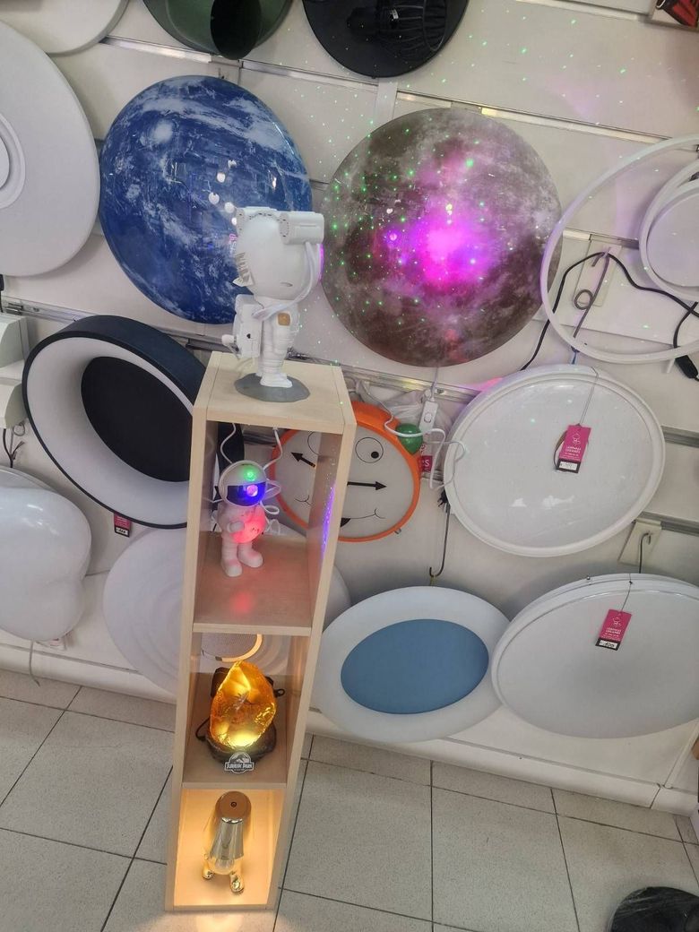 Un estante de exhibición en la tienda presenta luces decorativas, que incluyen figuras de astronautas