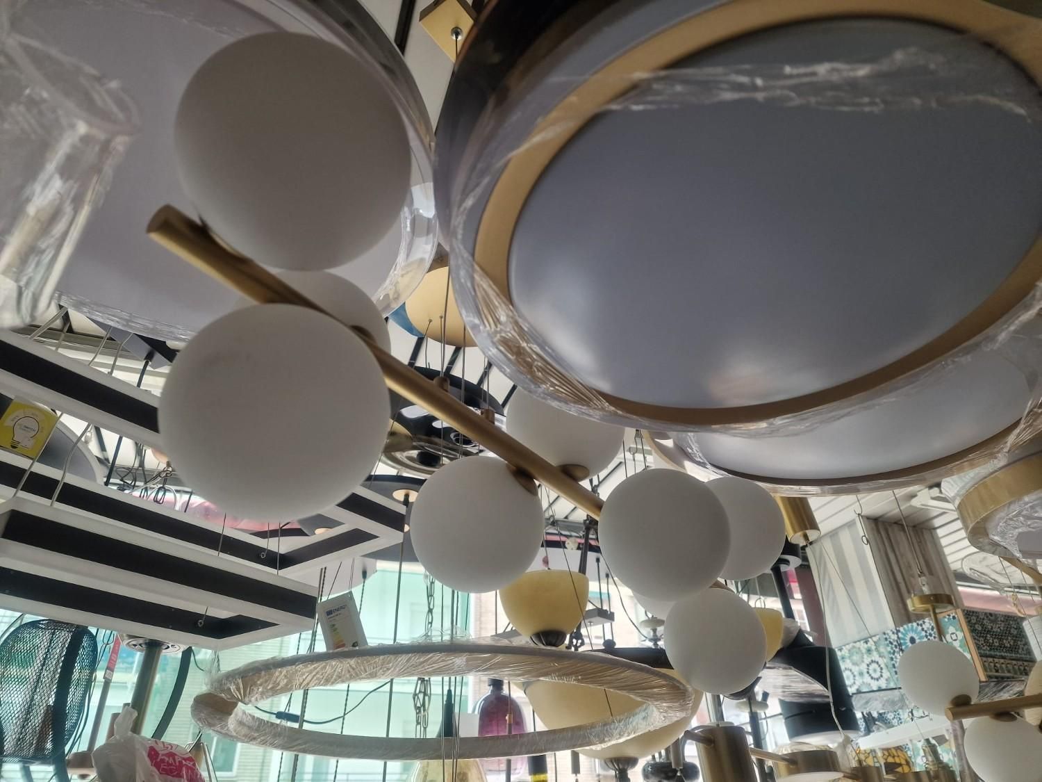 Una colección de lámparas colgantes y arañas modernas con globos de cristal blanco esmerilado