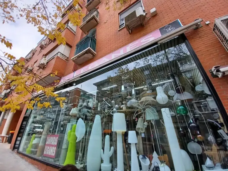 Un escaparate repleto de lámparas y luminarias, visto desde un ángulo bajo en un día de otoño.