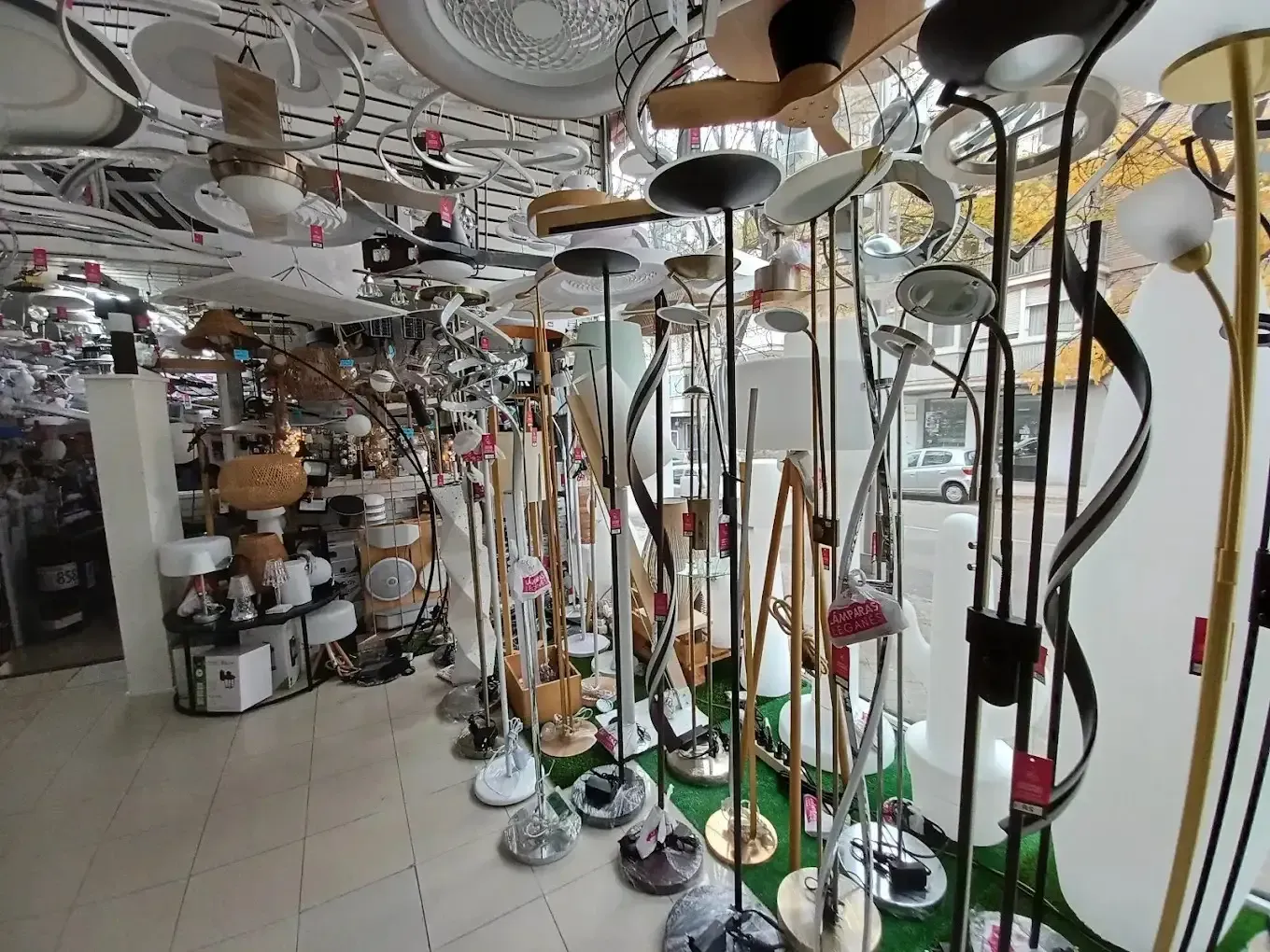 Una tienda repleta de lámparas de pie y plafones modernos, expuestos en una luminosa sala de exhibición.