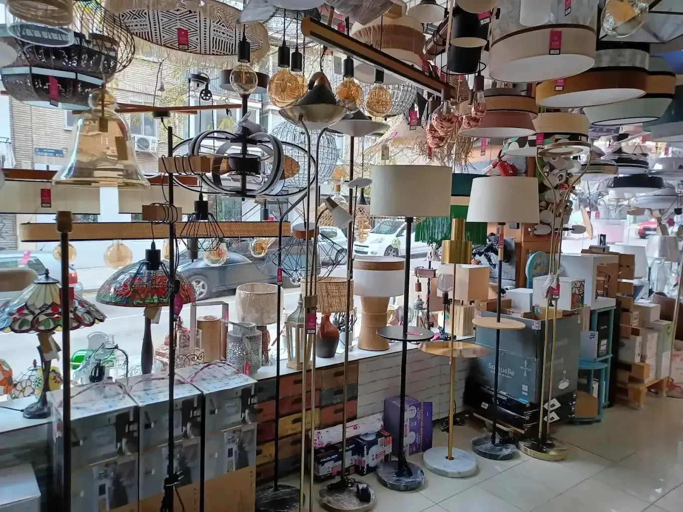 Una muestra de diversas luminarias de interior, incluyendo lámparas colgantes y de pie, dentro de una tienda.