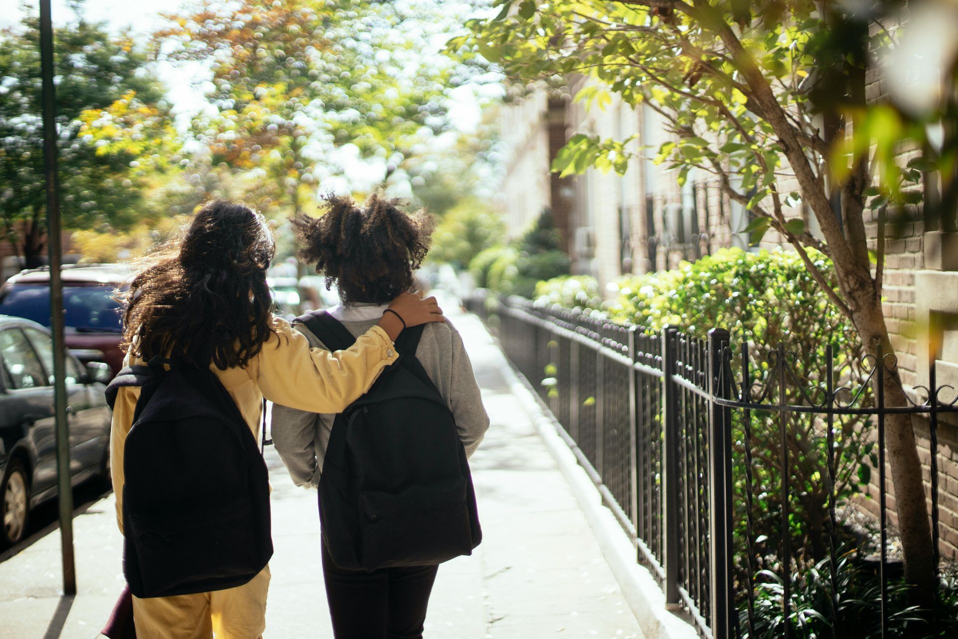 two girls wearing backpacks are walking