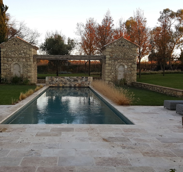Piscine avec deux tours en pierre apparente