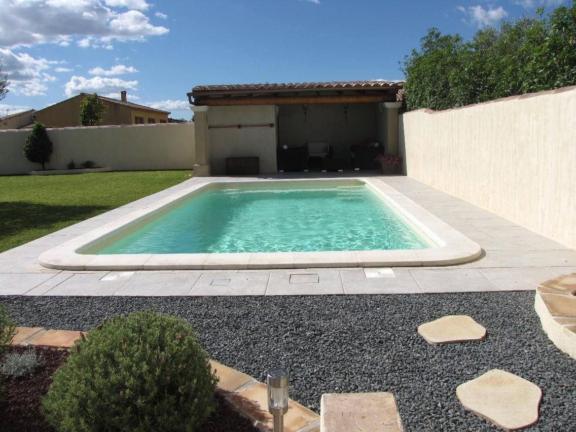 Piscine à coque avec du gravier et un chemin de pavés de pierre