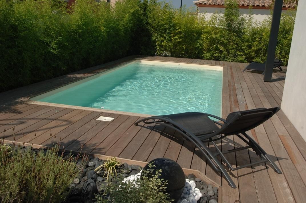 Piscine à coque avec un contour en bois et un transat
