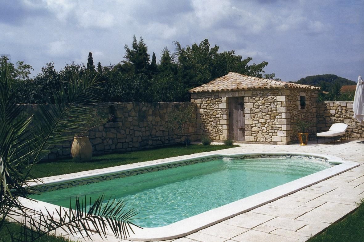 Piscine à coque avec une maisonnette en pierre apparente