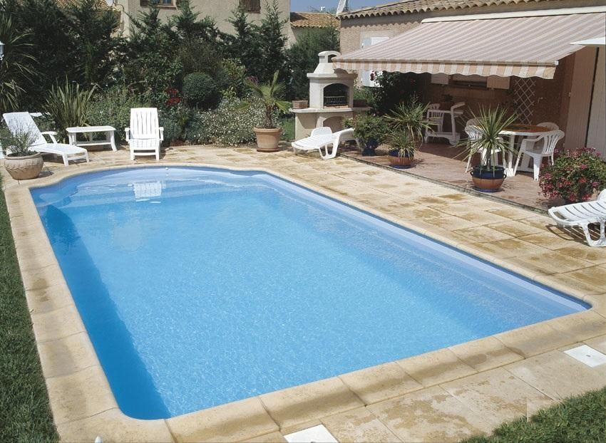 Piscine à coque avec des contours en pierre et une terrasse