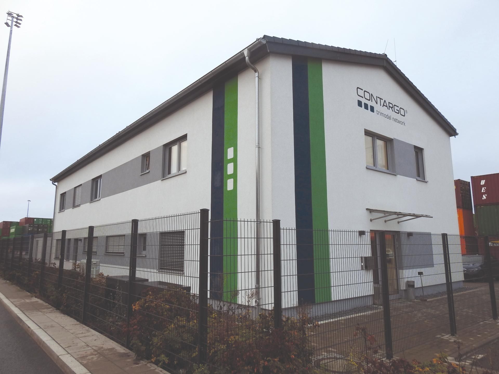 Foto | Eingezauntes neues Haus mit schwarzen und grünen Akzenten