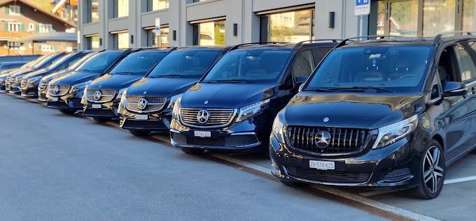 Eine Reihe schwarzer Mercedes-Transporter steht auf einem Parkplatz.