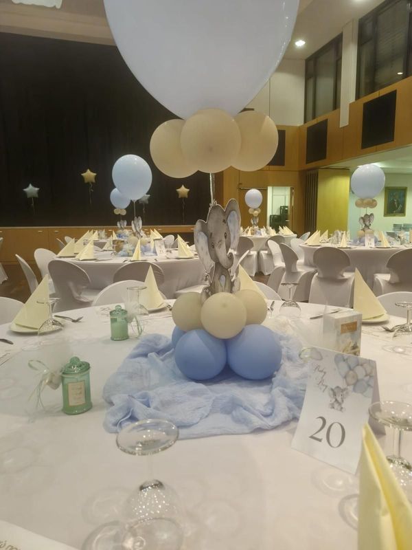 Tischdekoration mit Ballons in einem Bankettsaal mit weißer und cremefarbener Dekoration und Tischnummer 20