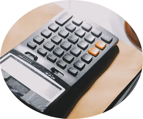 Una calculadora está encima de una mesa de madera.