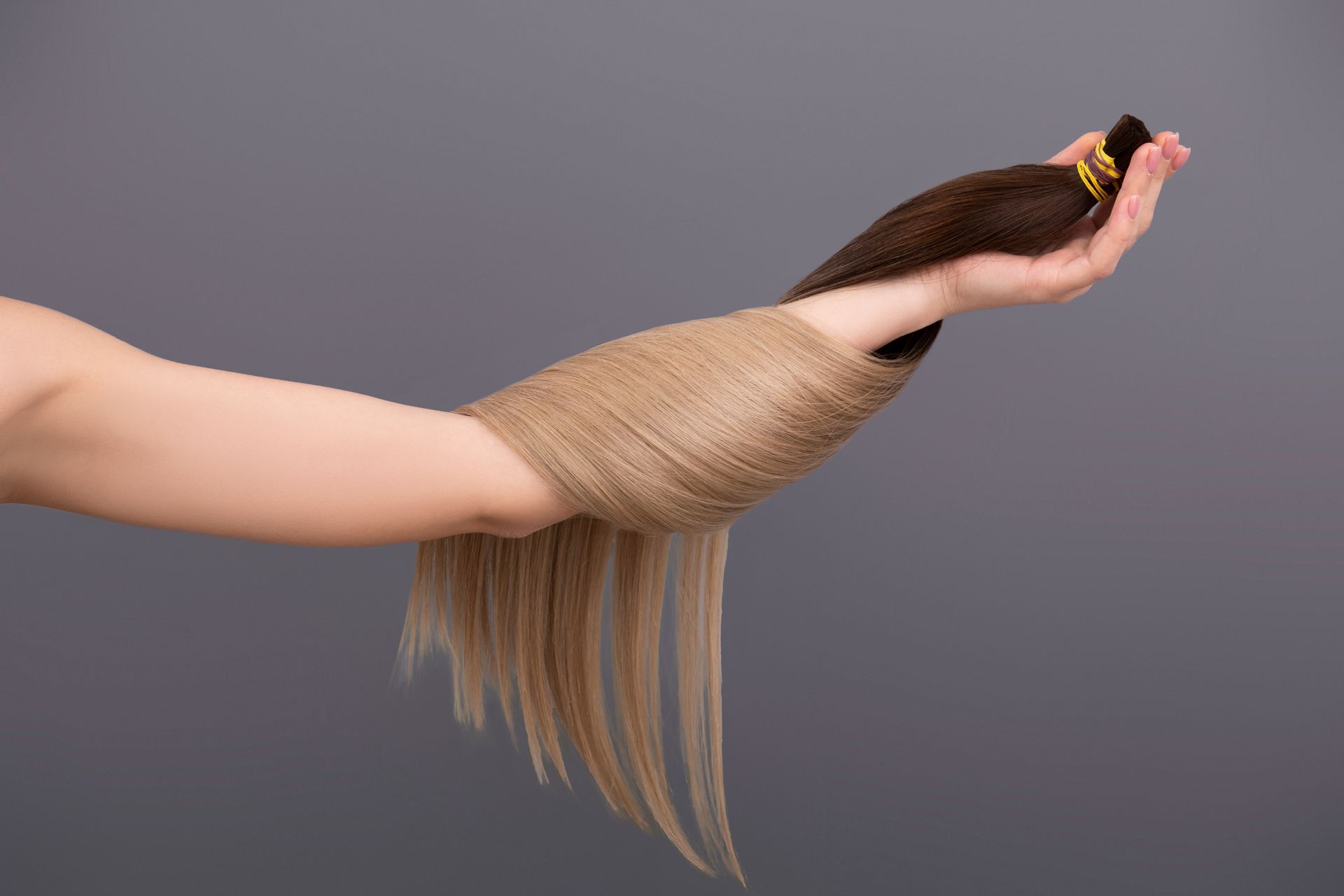 Eine Frau lässt sich in einem Salon von einem Friseur die Haare schneiden.