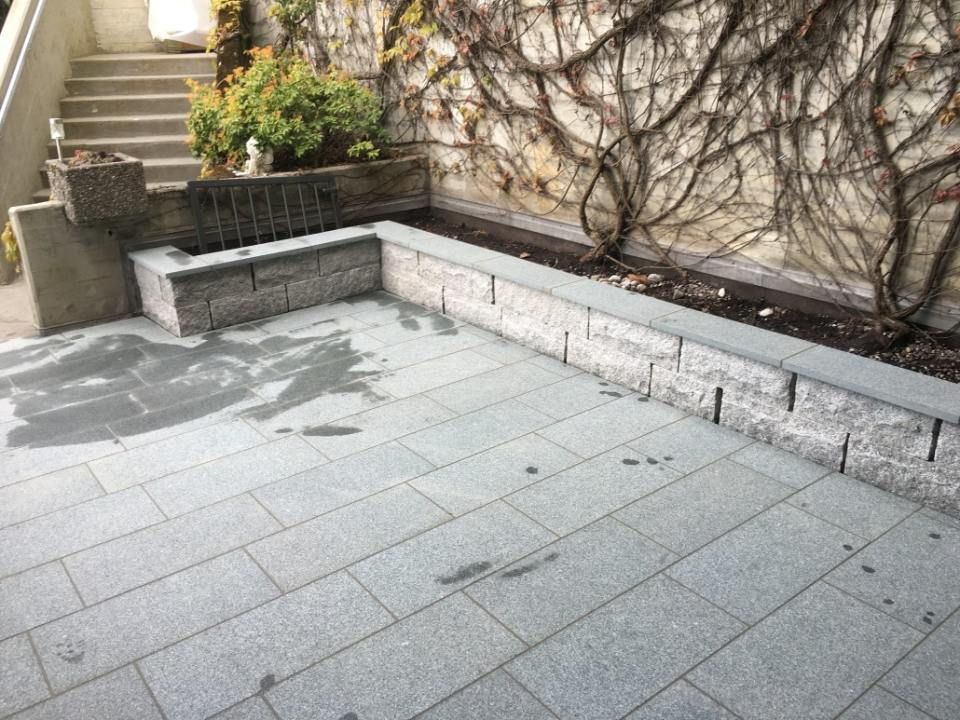 Steinterrasse mit Stützmauern, Stufen und Kletterpflanzen.