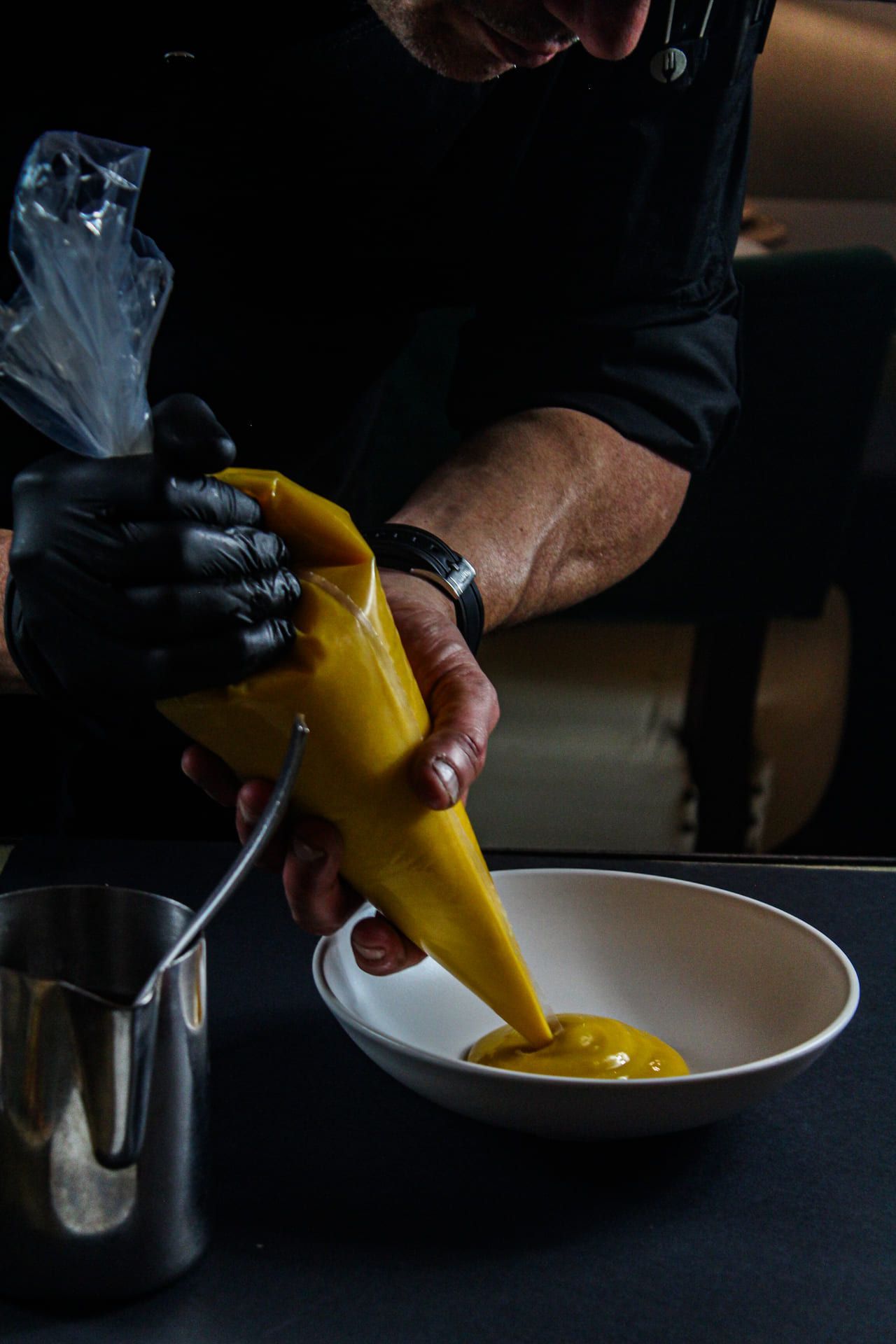 Una persona está vertiendo un líquido amarillo en un recipiente.