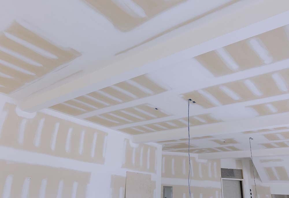 Una habitación con un techo que se está construyendo y recubriendo con paneles de yeso.