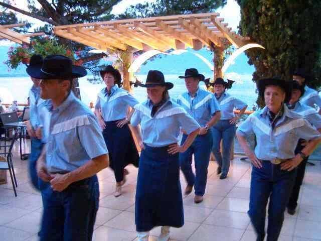 Un groupe de personnes portant des chapeaux de cow-boy dansent