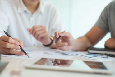 Zwei Personen arbeiten gemeinsam an einem Schreibtisch