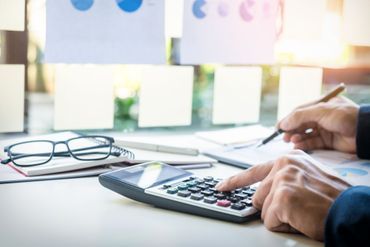 Person arbeitet mit einem Taschenrechner