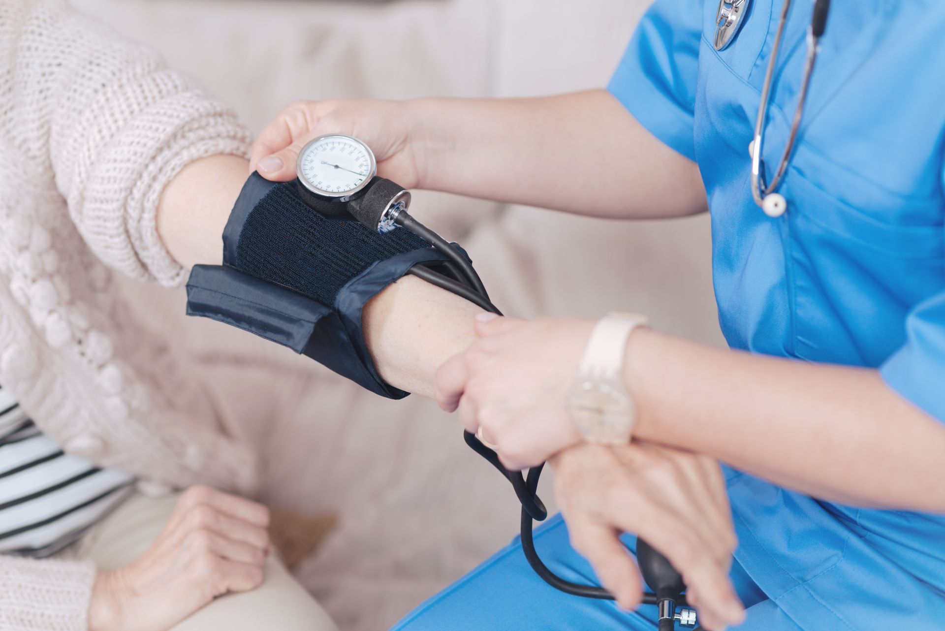 Un professionnel de santé prend la tension artérielle d'un patient à l'aide d'un brassard.