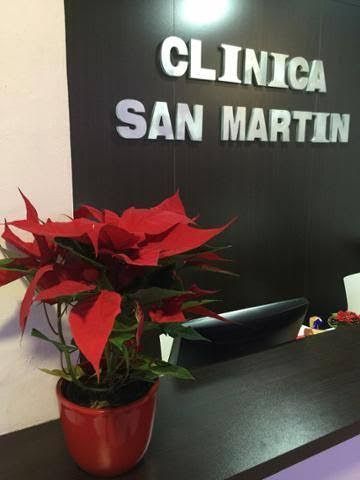 Planta de nochebuena roja en maceta sobre un mostrador con el cartel 