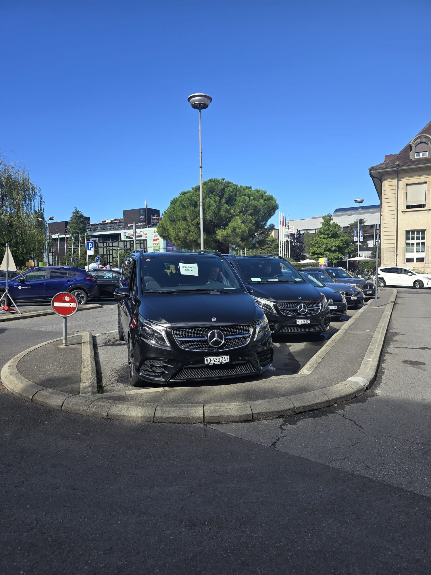 Des fourgonnettes Mercedes noires sont garées à un coin de rue.