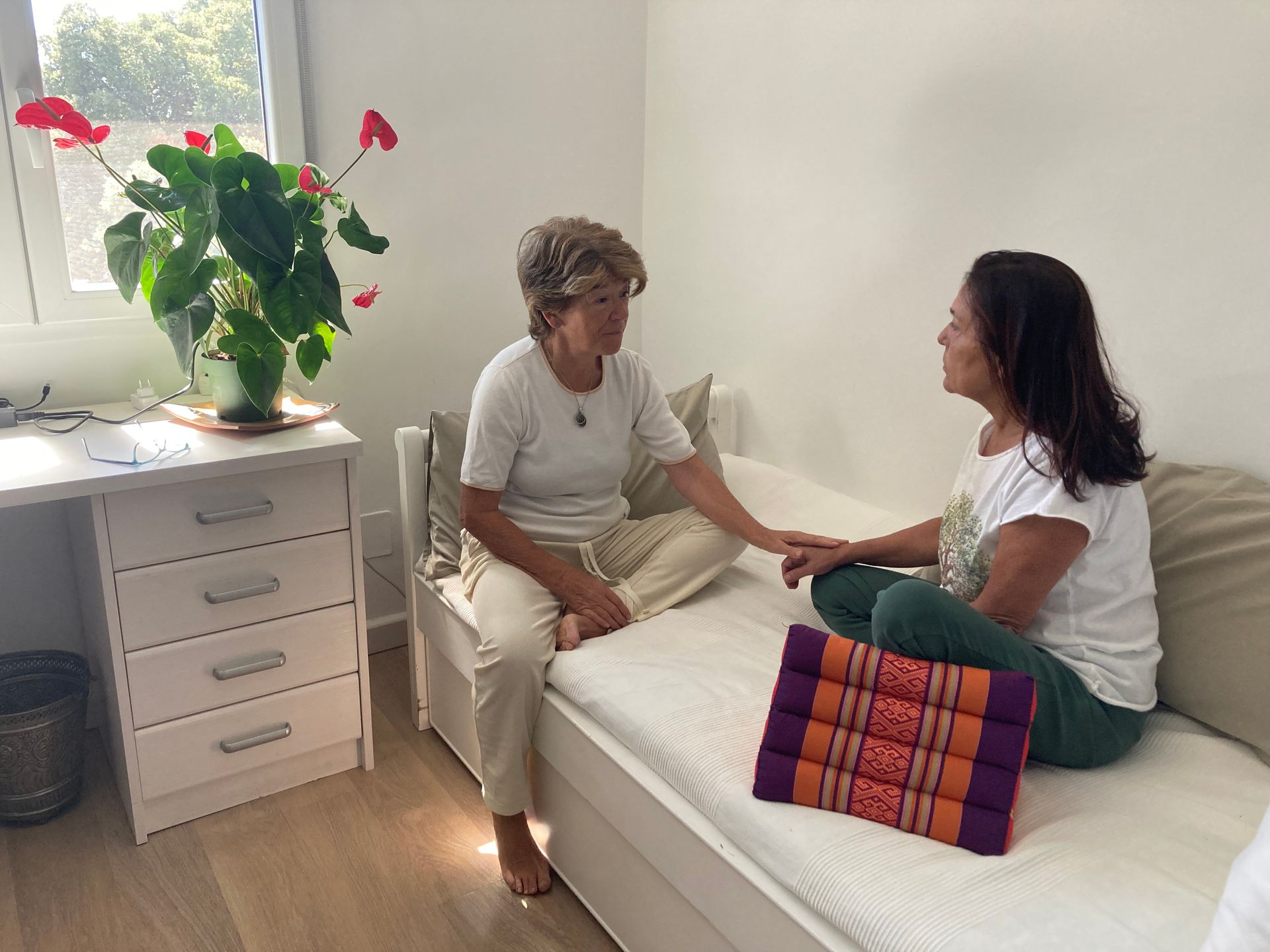 Una mujer con una camisa azul está parada frente a una escultura.
