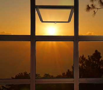 Una ventana con el sol brillando a través de ella