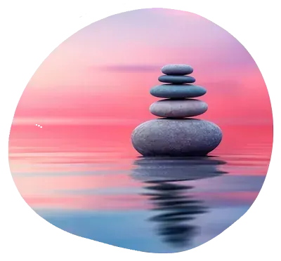 Una pila de rocas en el agua con un cielo rosado en el fondo.
