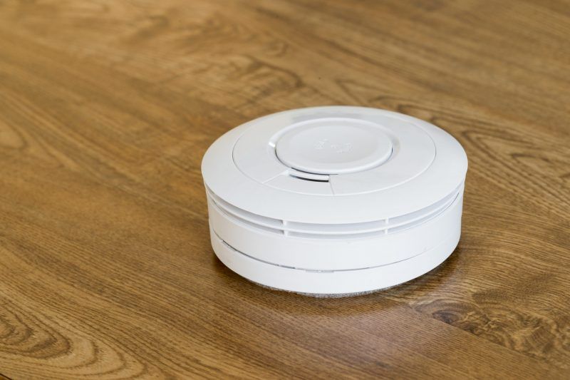 Aspirateur robot rond blanc sur un sol en bois