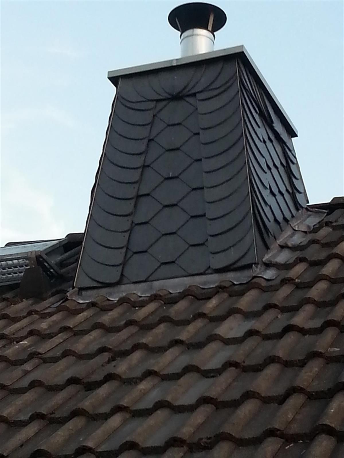 Ein Schornstein sitzt auf einem Ziegeldach