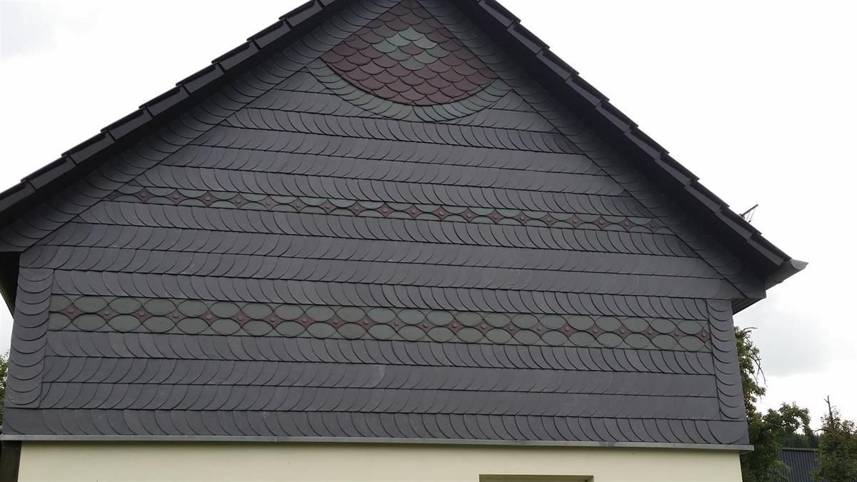 Auf dem Dach eines Hauses ist ein Wappen angebracht