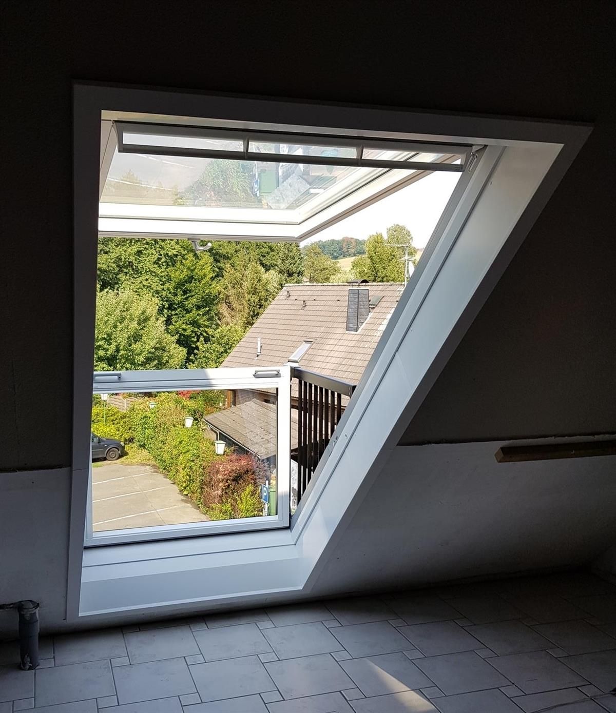Ein Fenster mit Blick auf ein Haus und Bäume