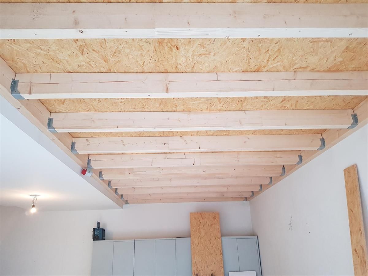 Ein Raum mit einer Decke aus Holzbalken.