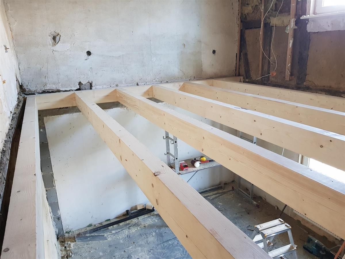 In einem Raum wird ein Holzboden eingebaut.