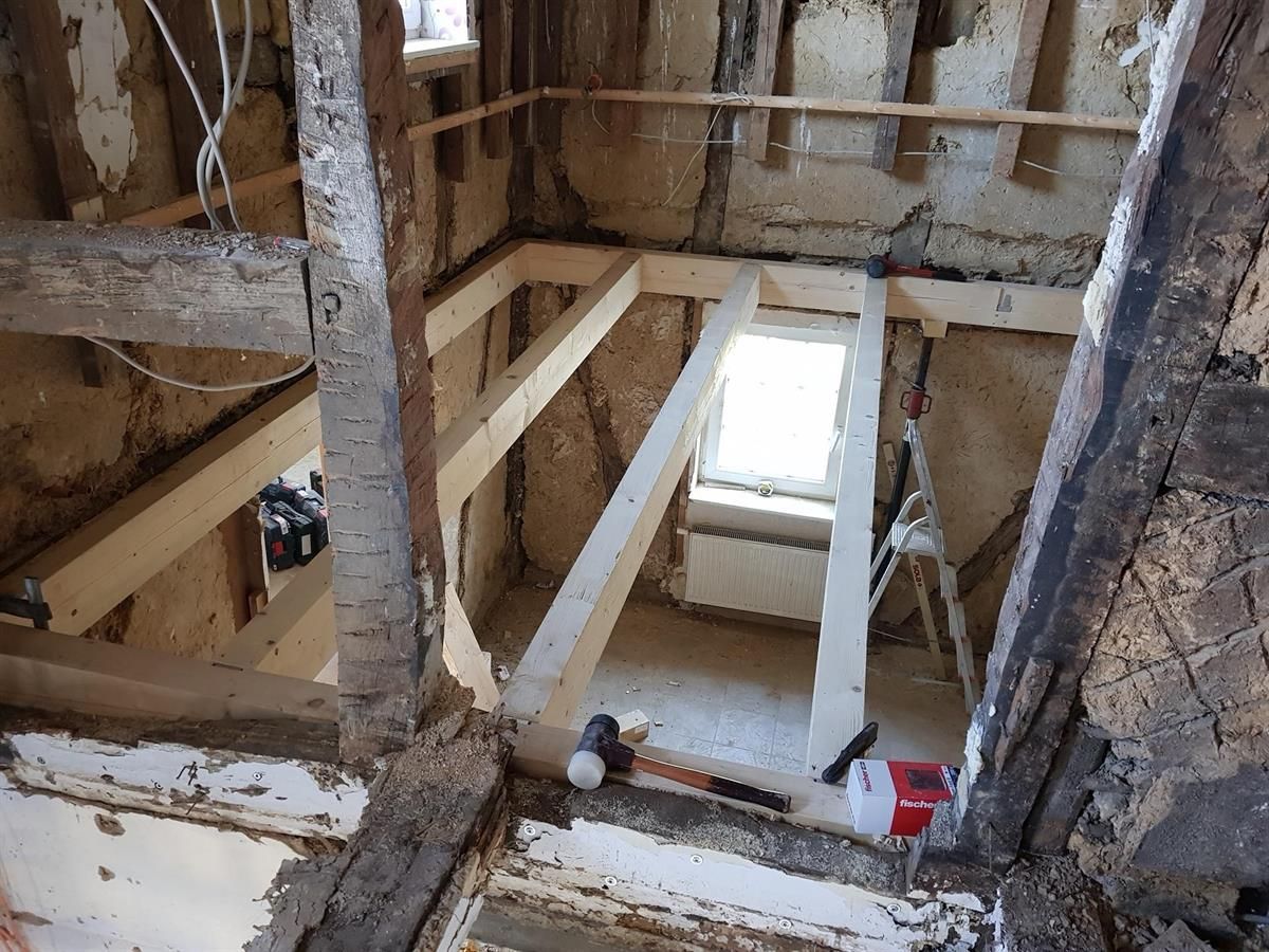 Ein Raum mit Holzbalken und einer Leiter darin