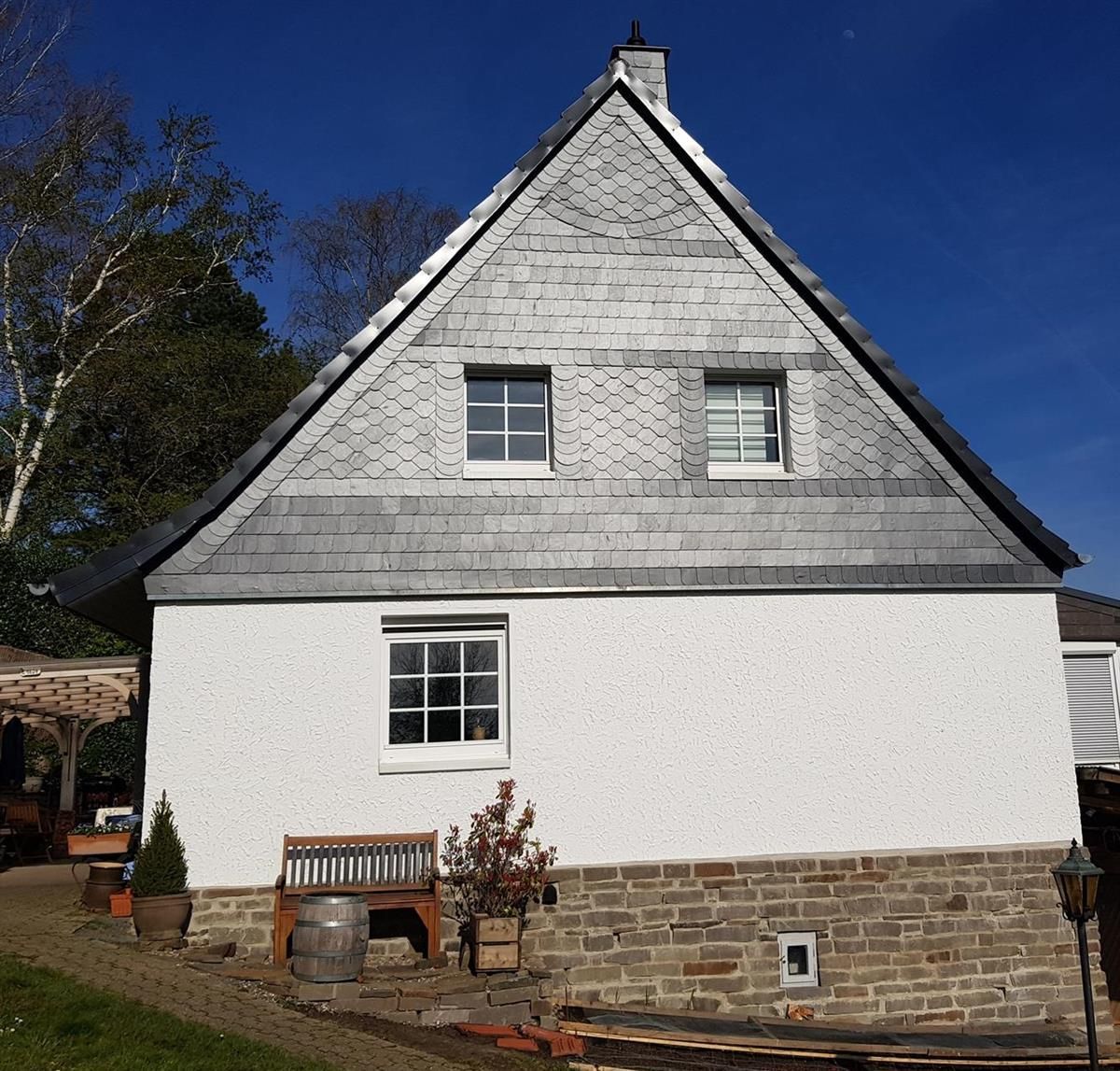 Ein weißes Haus mit einem dreieckigen Dach