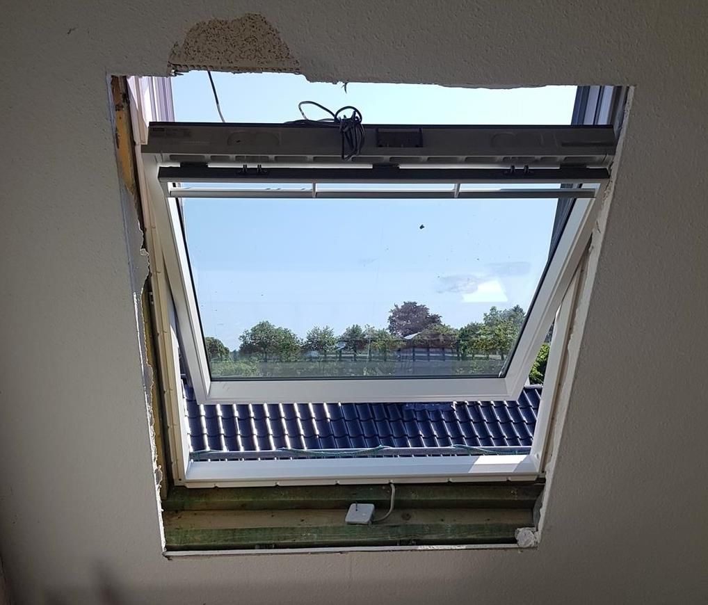 Ein Oberlicht mit Blick auf ein blaues Dach