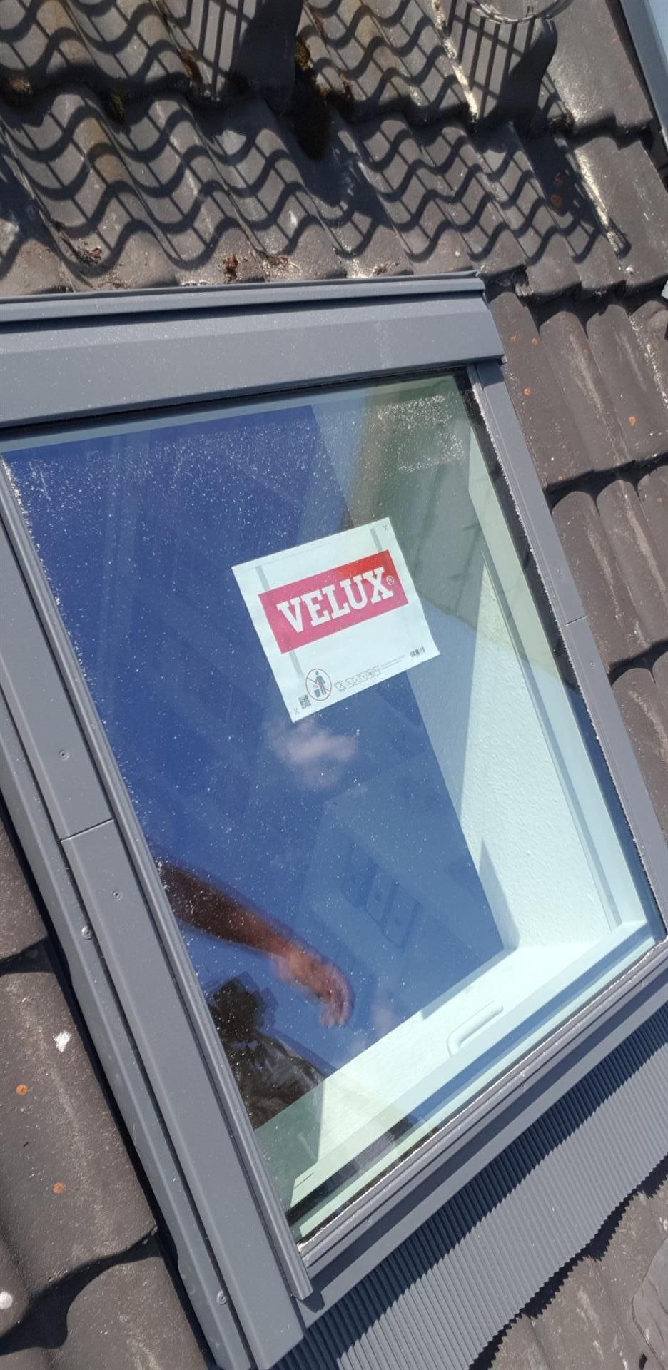 Auf einem Ziegeldach befindet sich ein Velux-Dachfenster.